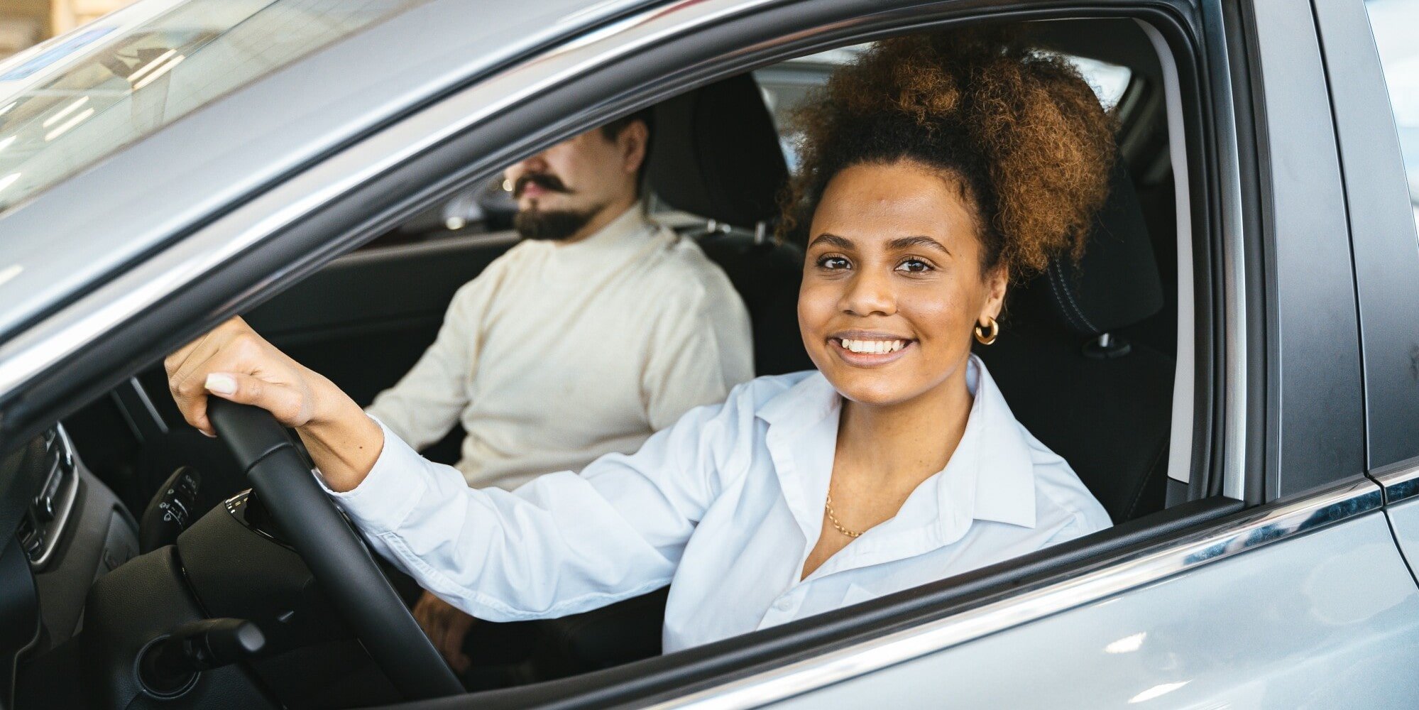 Woman driving car and smiling